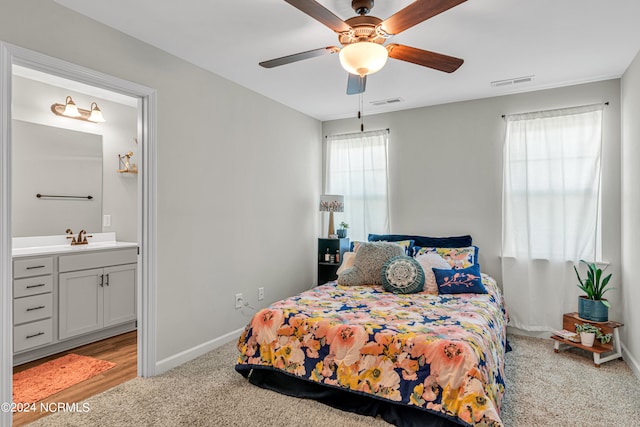 carpeted bedroom featuring connected bathroom, ceiling fan, and sink