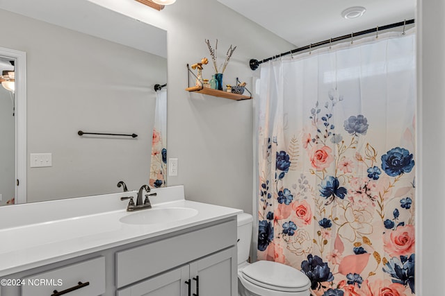 bathroom with vanity, curtained shower, and toilet