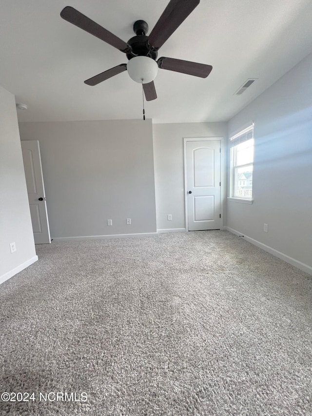 unfurnished room with ceiling fan and carpet