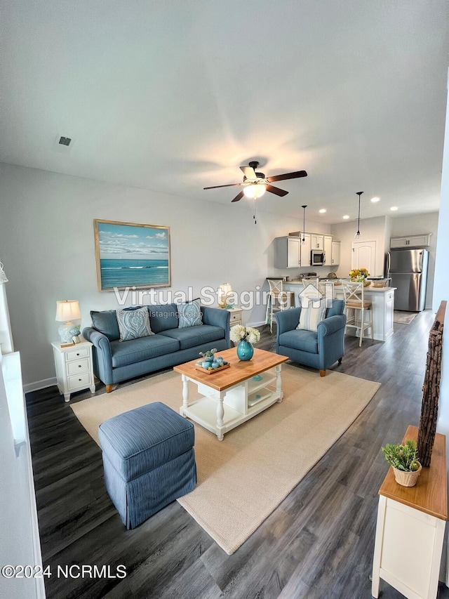 living room with ceiling fan and dark hardwood / wood-style flooring