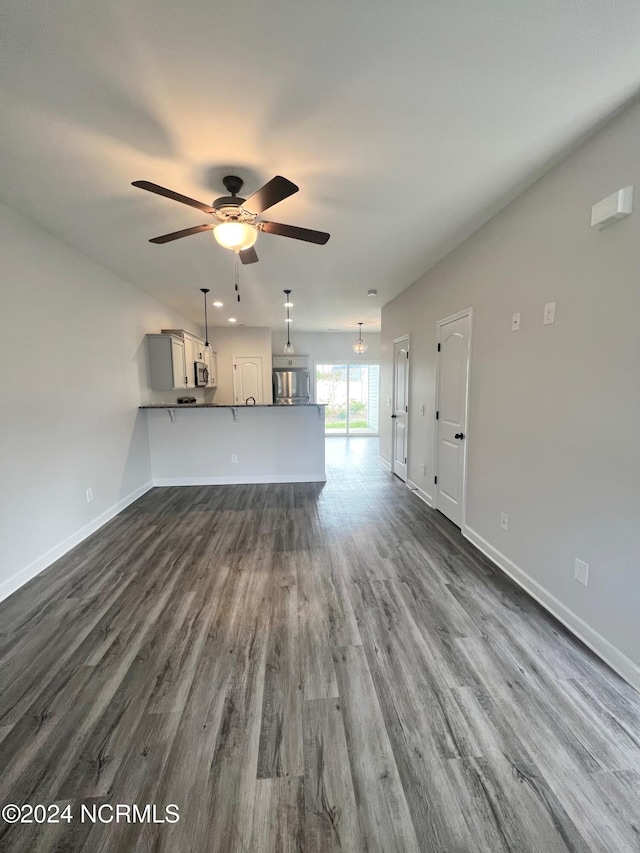 unfurnished living room featuring dark hardwood / wood-style floors and ceiling fan