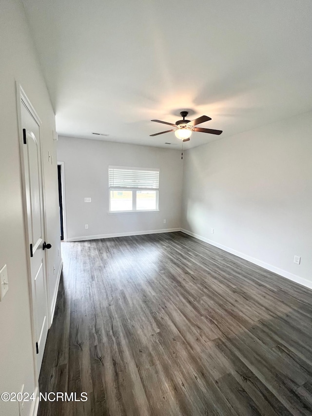 unfurnished room with ceiling fan and dark hardwood / wood-style flooring