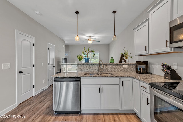 kitchen featuring appliances with stainless steel finishes, white cabinetry, sink, and light hardwood / wood-style floors