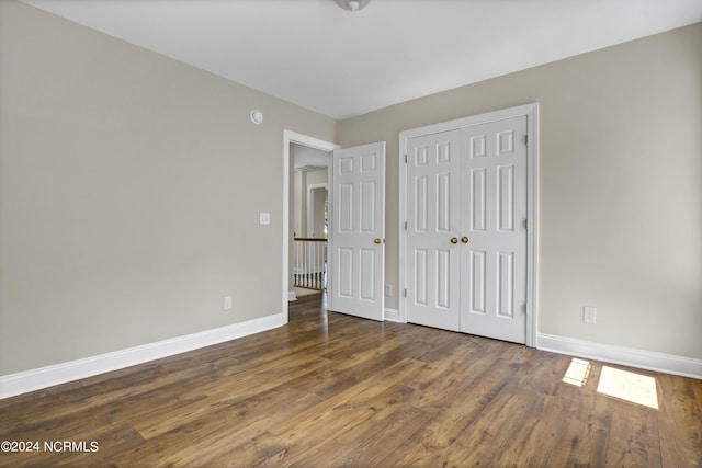 unfurnished bedroom featuring dark hardwood / wood-style floors and a closet