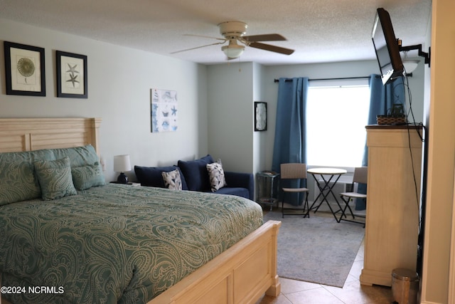 tiled bedroom featuring ceiling fan and a textured ceiling