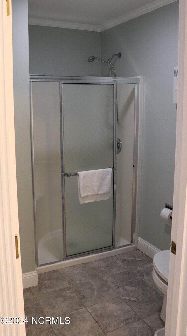 bathroom featuring an enclosed shower, tile patterned floors, toilet, and crown molding