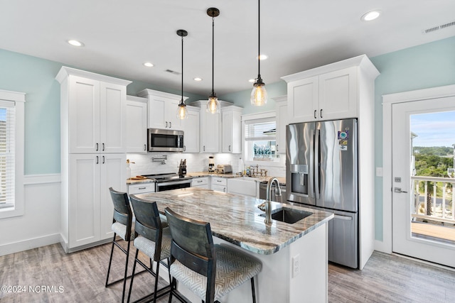445 E Third St, Ocean Isle Beach, NC 28469 - kitchen with appliances with stainless steel finishes, a sink, light wood finished floors, healthy amount of natural light, and recessed lighting
