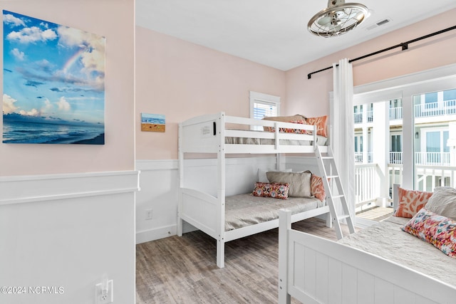 445 E Third St, Ocean Isle Beach, NC 28469 - bedroom featuring wood finished floors and wainscoting