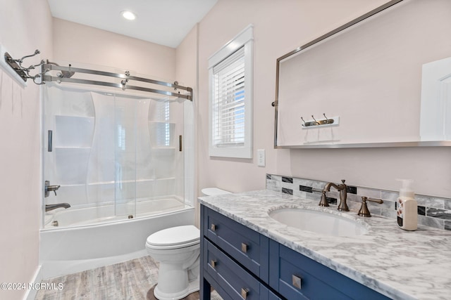 445 E Third St, Ocean Isle Beach, NC 28469 - full bathroom featuring toilet, vanity, wood finished floors, and combined bath / shower with glass door