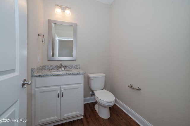 bathroom with wood-type flooring, vanity, and toilet