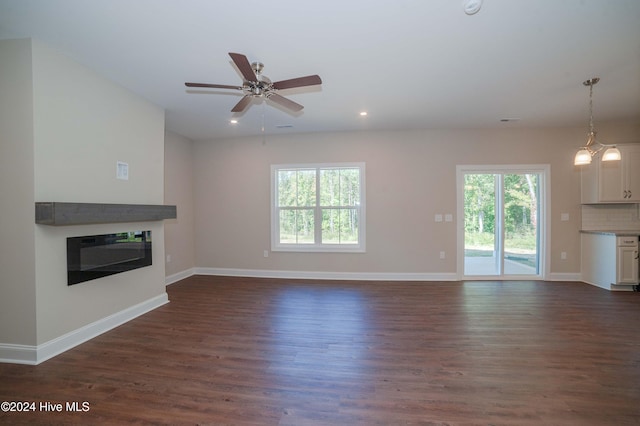 unfurnished living room featuring a wealth of natural light, dark hardwood / wood-style flooring, and ceiling fan