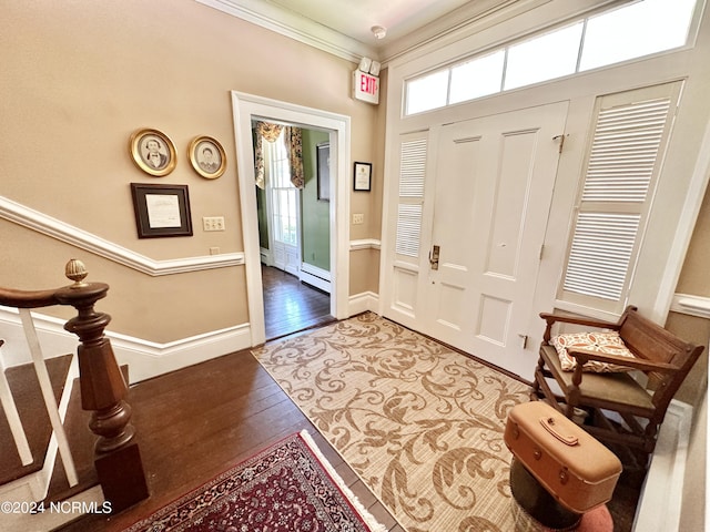 foyer with wood finished floors, baseboards, ornamental molding, stairway, and baseboard heating