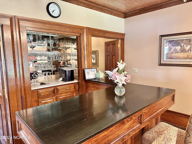 dining space with ornamental molding and a bar