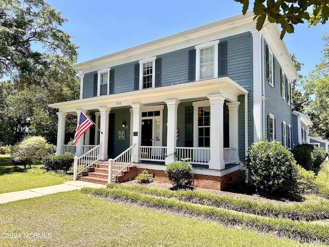 view of front facade featuring covered porch and a front lawn