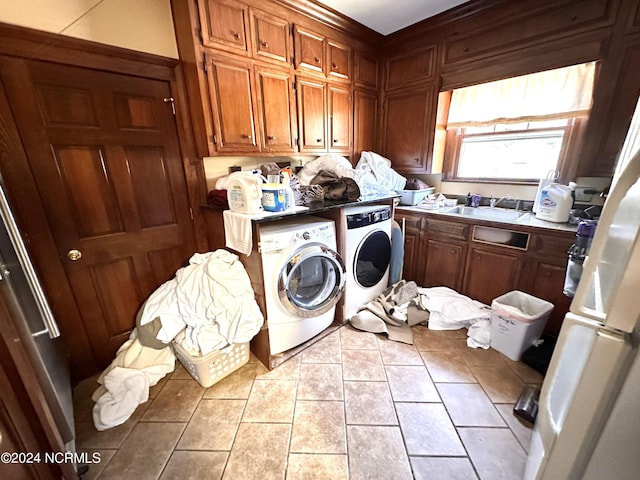 washroom featuring light tile patterned floors, a sink, cabinet space, and washer and dryer