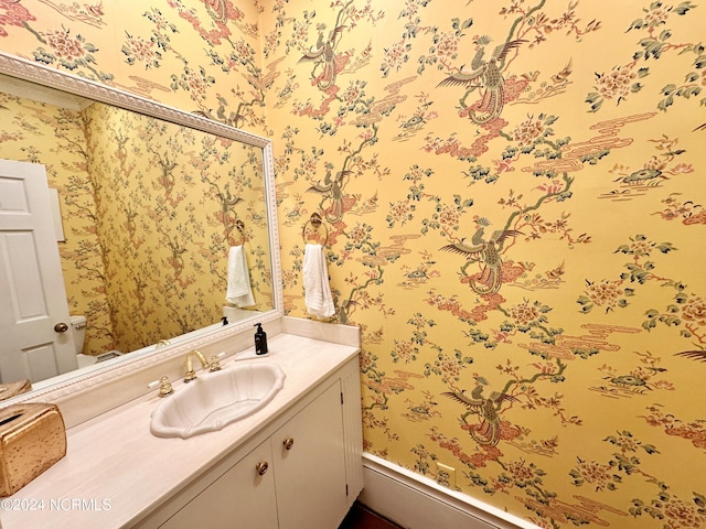 bathroom with vanity and wallpapered walls