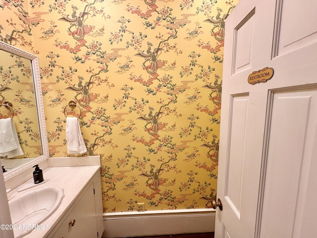 bathroom with vanity and wallpapered walls