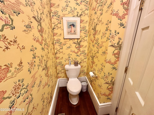 bathroom with baseboards, wood finished floors, toilet, and wallpapered walls