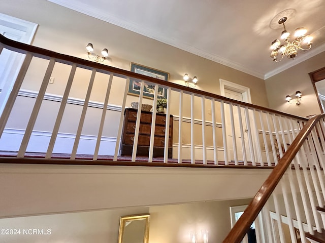 stairway featuring a chandelier and ornamental molding