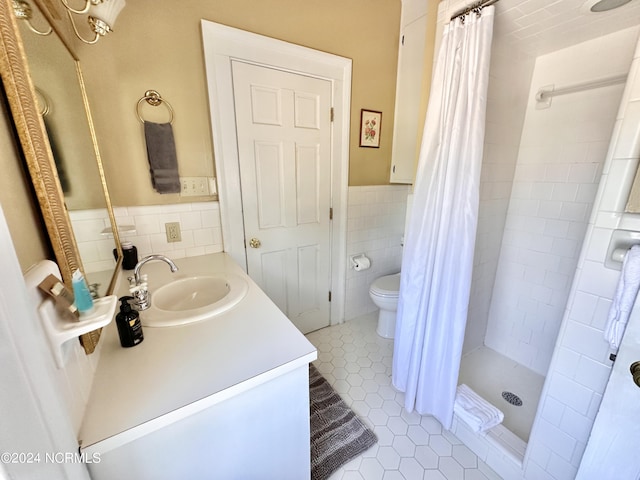 bathroom featuring toilet, tile patterned floors, vanity, a shower stall, and tile walls