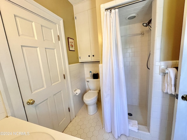 full bathroom featuring a wainscoted wall, tile walls, toilet, a stall shower, and tile patterned floors