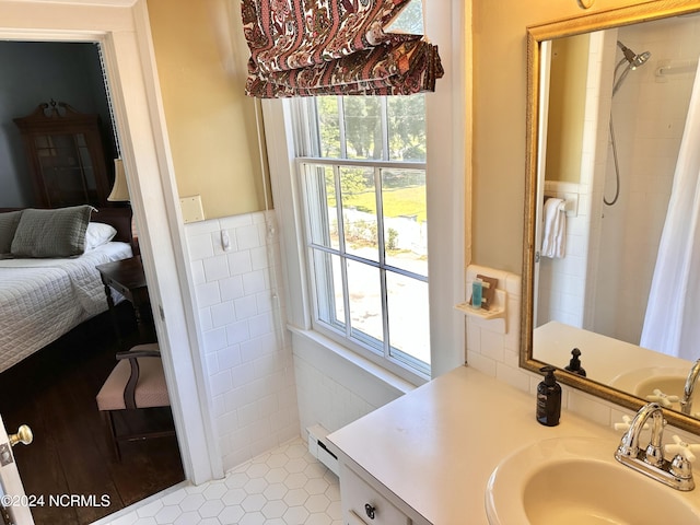 bathroom with a healthy amount of sunlight, baseboard heating, tile walls, and ensuite bathroom