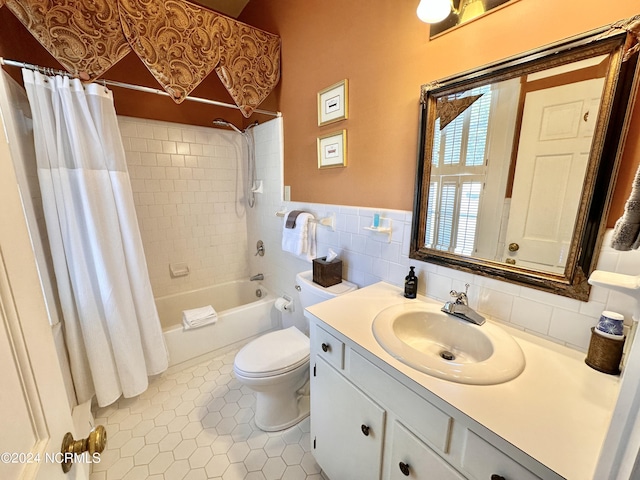 bathroom featuring tile patterned flooring, toilet, vanity, tile walls, and shower / bath combo with shower curtain