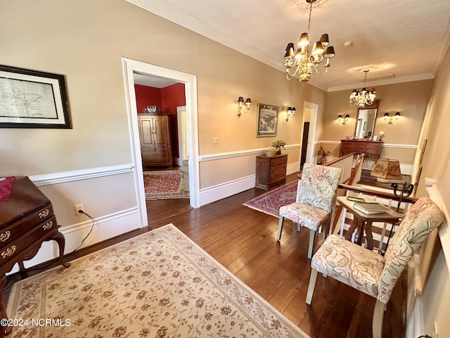 living area featuring baseboards, a chandelier, wood finished floors, and ornamental molding