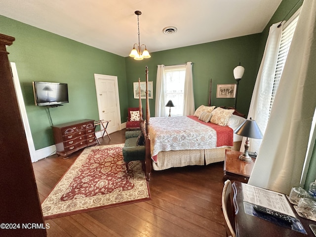 bedroom with dark wood-style floors, baseboards, visible vents, and a notable chandelier