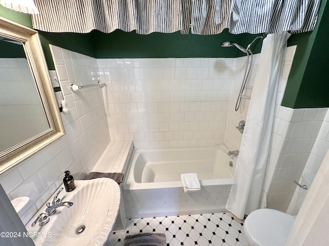 full bathroom with toilet, shower / tub combo, a sink, and tile walls