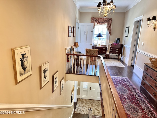 hallway featuring baseboards, crown molding, a chandelier, and dark wood-type flooring