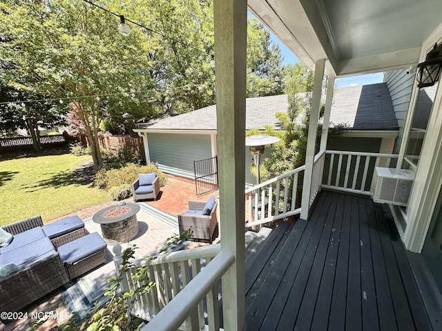 wooden terrace with a lawn, cooling unit, an outdoor living space with a fire pit, and fence