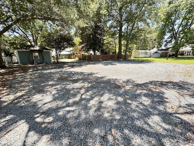 view of yard with driveway and fence