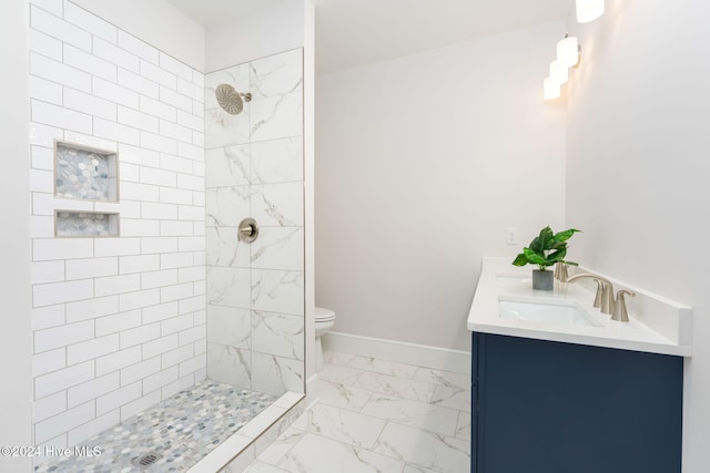 112 Seagate Pl, Wilmington, NC 28403 - bathroom with marble look tiles, double vanity, a tile shower, baseboards, and toilet