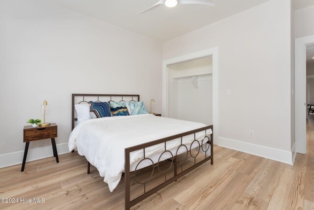 bedroom with hardwood / wood-style flooring, ceiling fan, and a closet