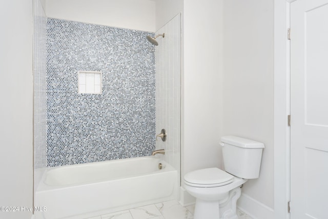 bathroom featuring toilet and tiled shower / bath