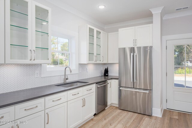 kitchen featuring white cabinets, appliances with stainless steel finishes, light wood-type flooring, and sink