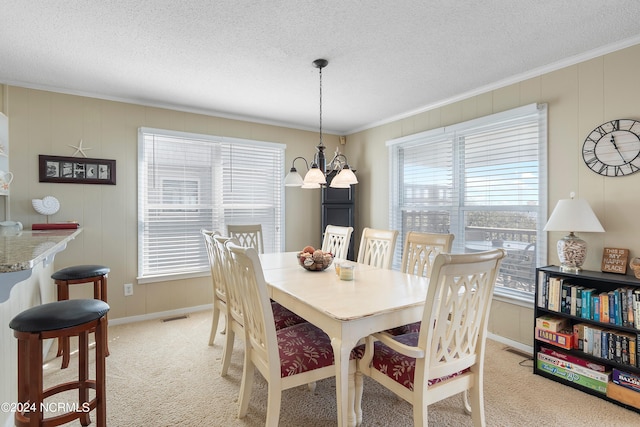 dining space featuring ornamental molding, a chandelier, light colored carpet, and plenty of natural light