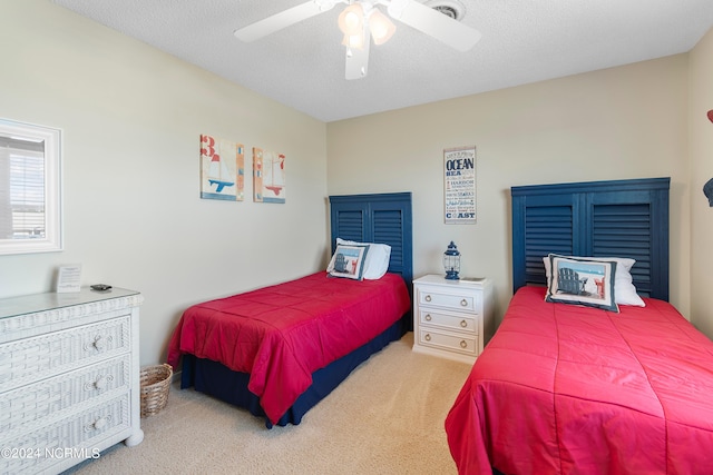 carpeted bedroom featuring ceiling fan and a textured ceiling