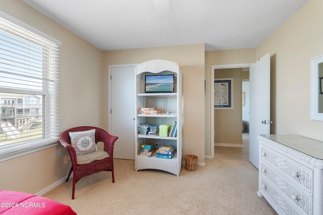 carpeted bedroom with multiple windows, a textured ceiling, and ceiling fan