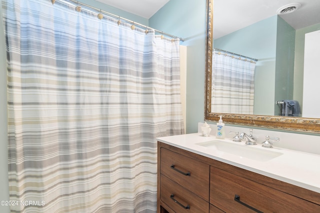 bathroom with walk in shower and vanity