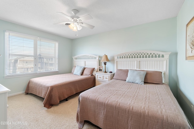 bedroom with a textured ceiling, ceiling fan, and light colored carpet