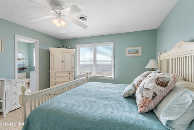 carpeted bedroom featuring ceiling fan and a textured ceiling