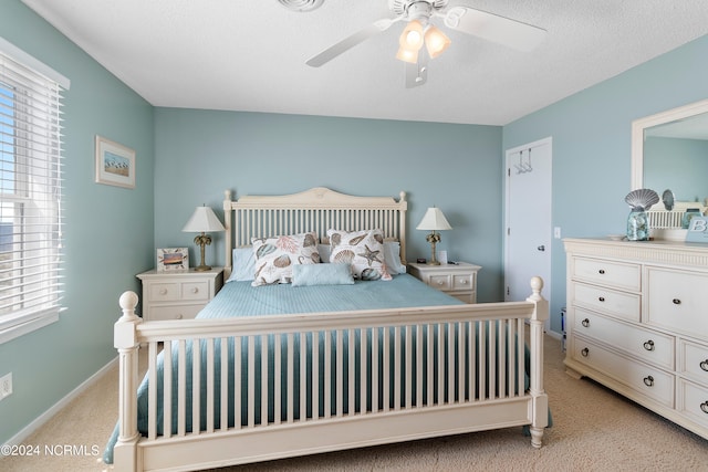 carpeted bedroom featuring a textured ceiling and ceiling fan