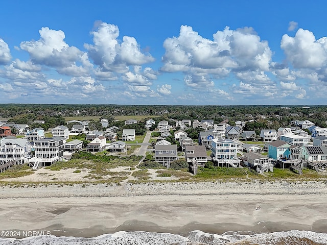 birds eye view of property with a water view and a beach view