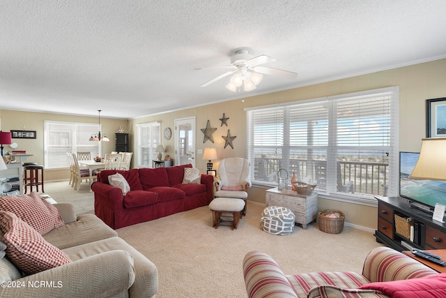 living room featuring ceiling fan, ornamental molding, and carpet flooring