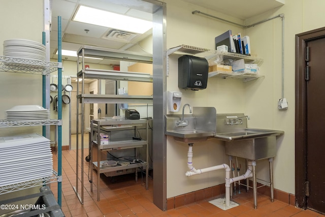 misc room with tile patterned floors and sink