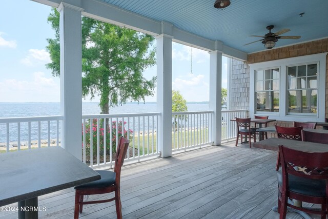 sunroom / solarium featuring ceiling fan and a water view