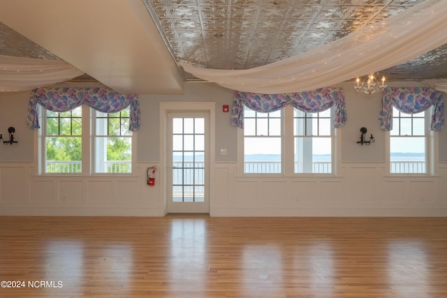 interior space with plenty of natural light, an inviting chandelier, and light hardwood / wood-style flooring