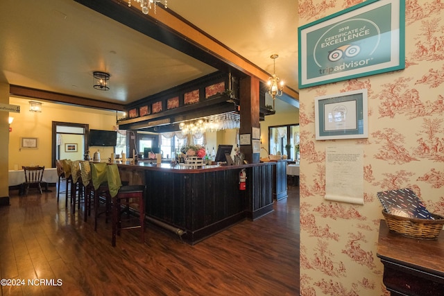 bar featuring a chandelier and dark hardwood / wood-style floors